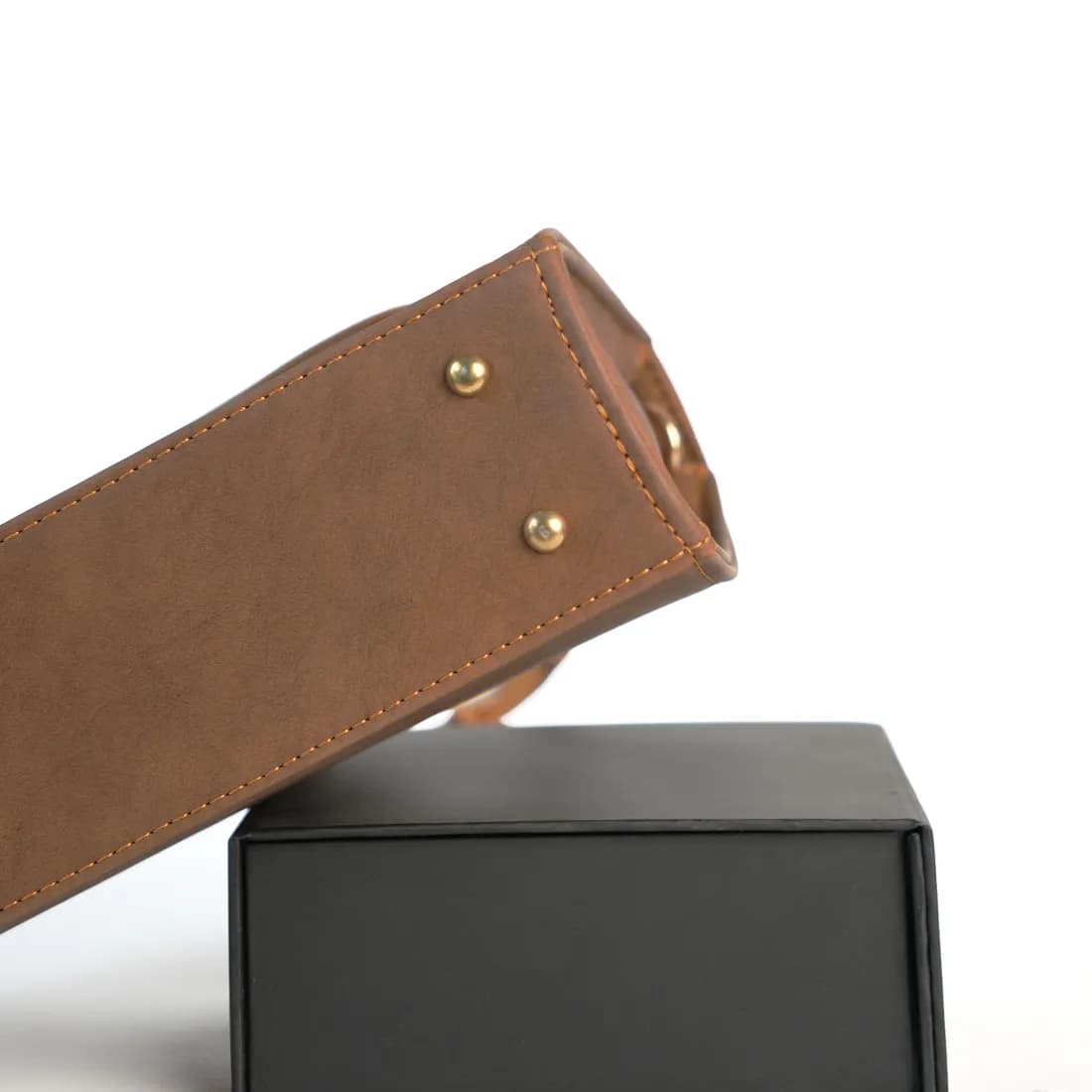Malang shoulder bag resting on the black Malang box