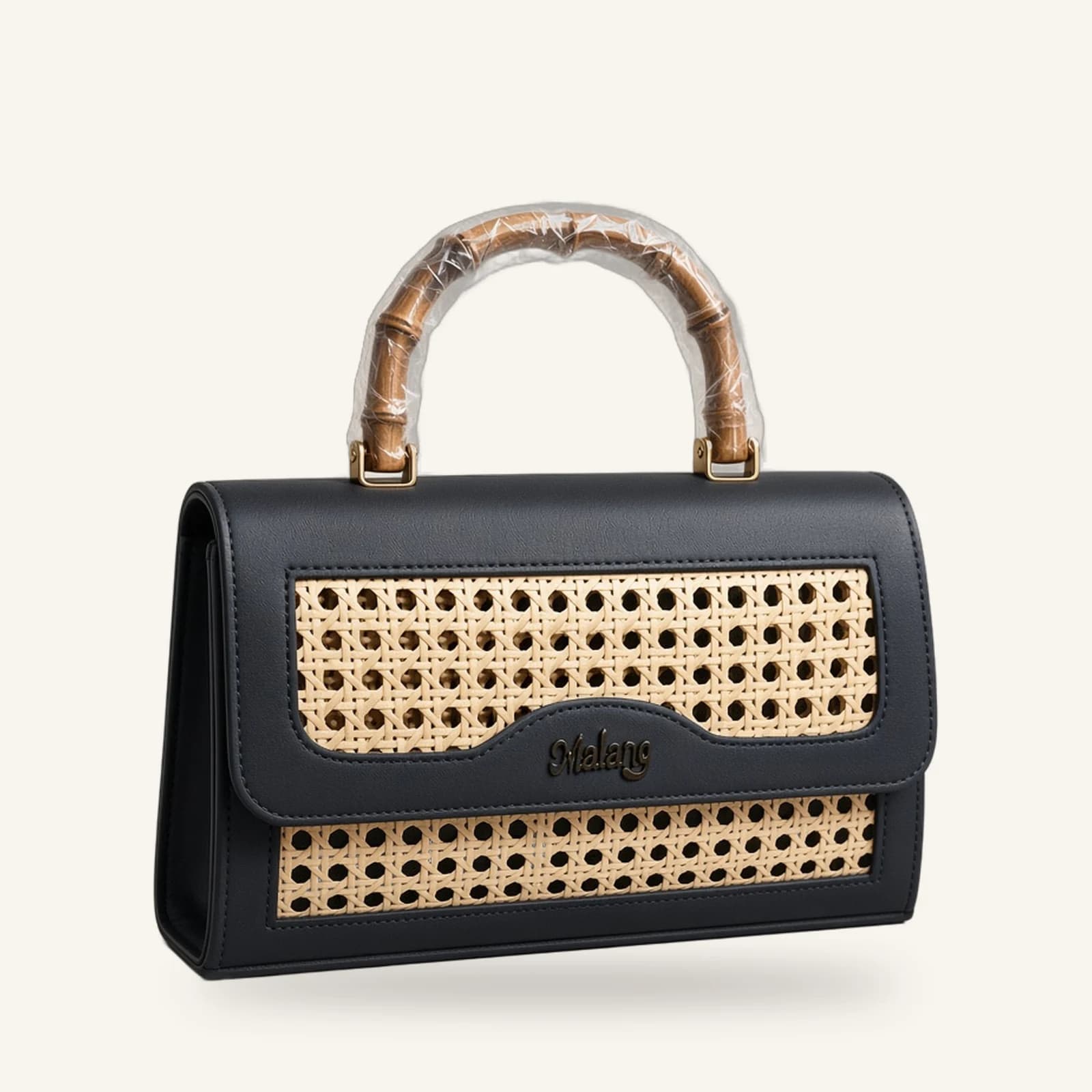 The Malang Top Handle — black cane and vegan-leather handbag with bamboo handle, on an ivory background